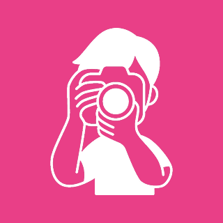 Icon of a person with a camera on a pink background, capturing an image with their right hand on the shutter button and left hand supporting the lens.
